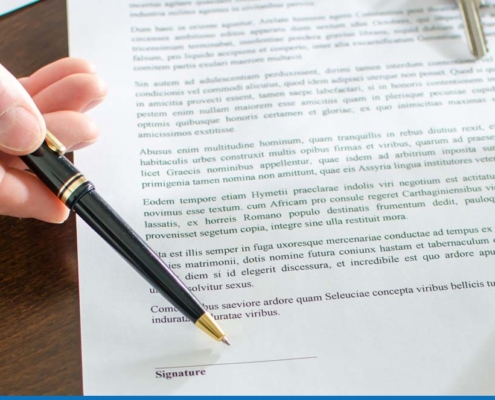Person signing real estate contract with a pen.