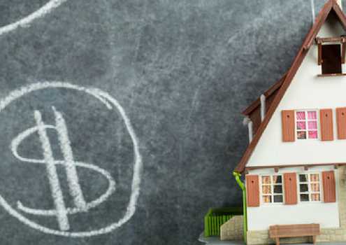 Shows dollar signs on black board next to 3d model home