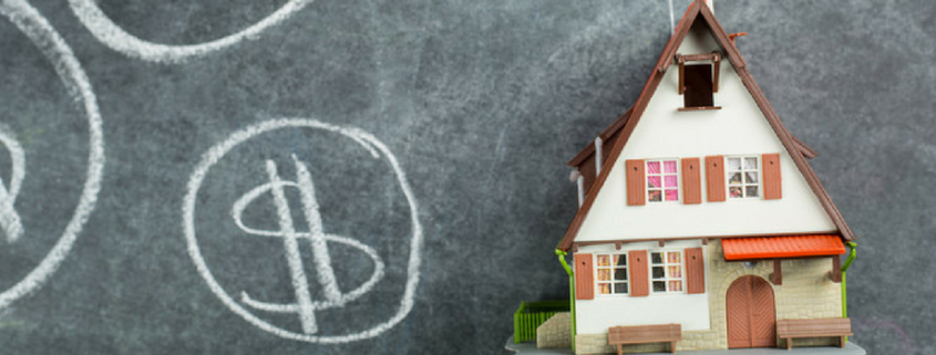 Shows dollar signs on black board next to 3d model home