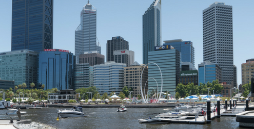 Skyline of Perth at the harbor, boats in the water, buildings in the background.