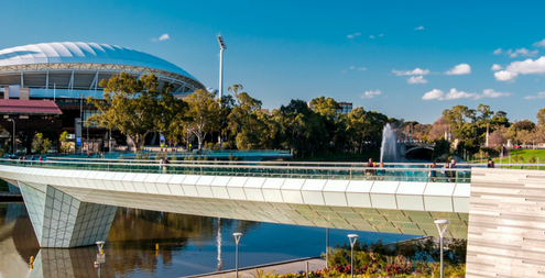 Adelaide Oval and foot bridge viewed across Elder Park on a bright day