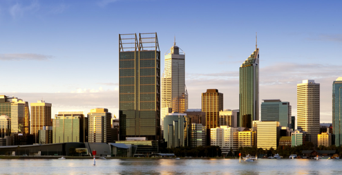 Image of Perth at dusk, highrise buildings in the back ground, with a clear blue sky.